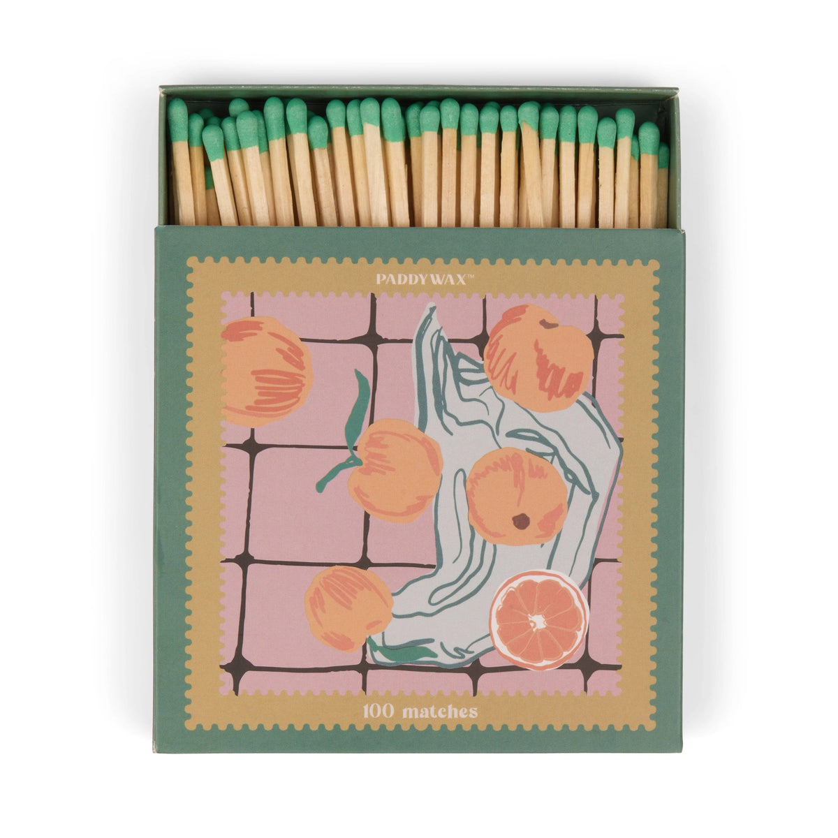 A box of 100 jumbo green-tipped matches, "Oranges - Green Matches," comes in an artful matchbox adorned with peaches and sliced citrus on a pink-tiled background—a stylish candle accessory.
