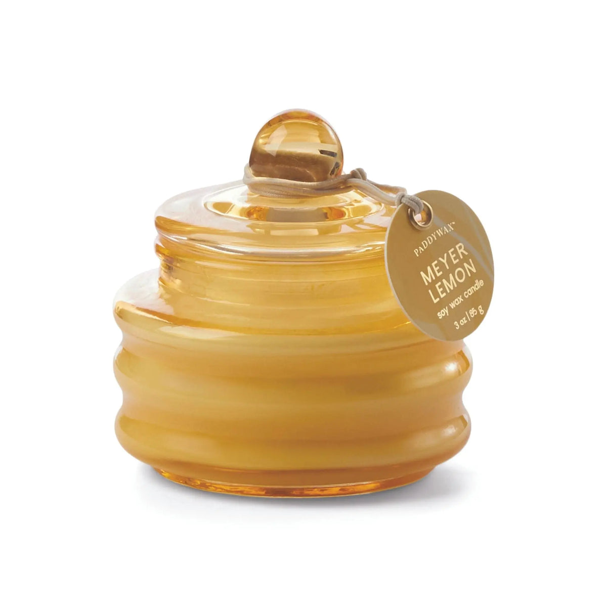 The Meyer Lemon - Beam 3 oz Candle is a yellow glass beehive-shaped jar with a lid, ambient light, and a round gold tag, filled with Meyer Lemon-scented soy wax for a luxurious aroma in your space.