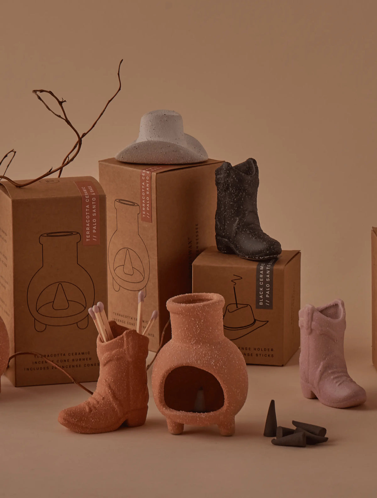 Cotton & Teak - Incense Holder, including ceramic boot shapes, a cowboy hat holder, and a chiminea, are styled with gift boxes, incense cones, and dried branches—an ideal Nashville-inspired gift set on a neutral backdrop.