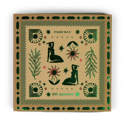 The Femme - Green Matches matchbox holds 100 jumbo matches and displays geometric patterns, abstract figures, plants, and sun motifs in green and red on a tan background—perfect as a candle accessory.
