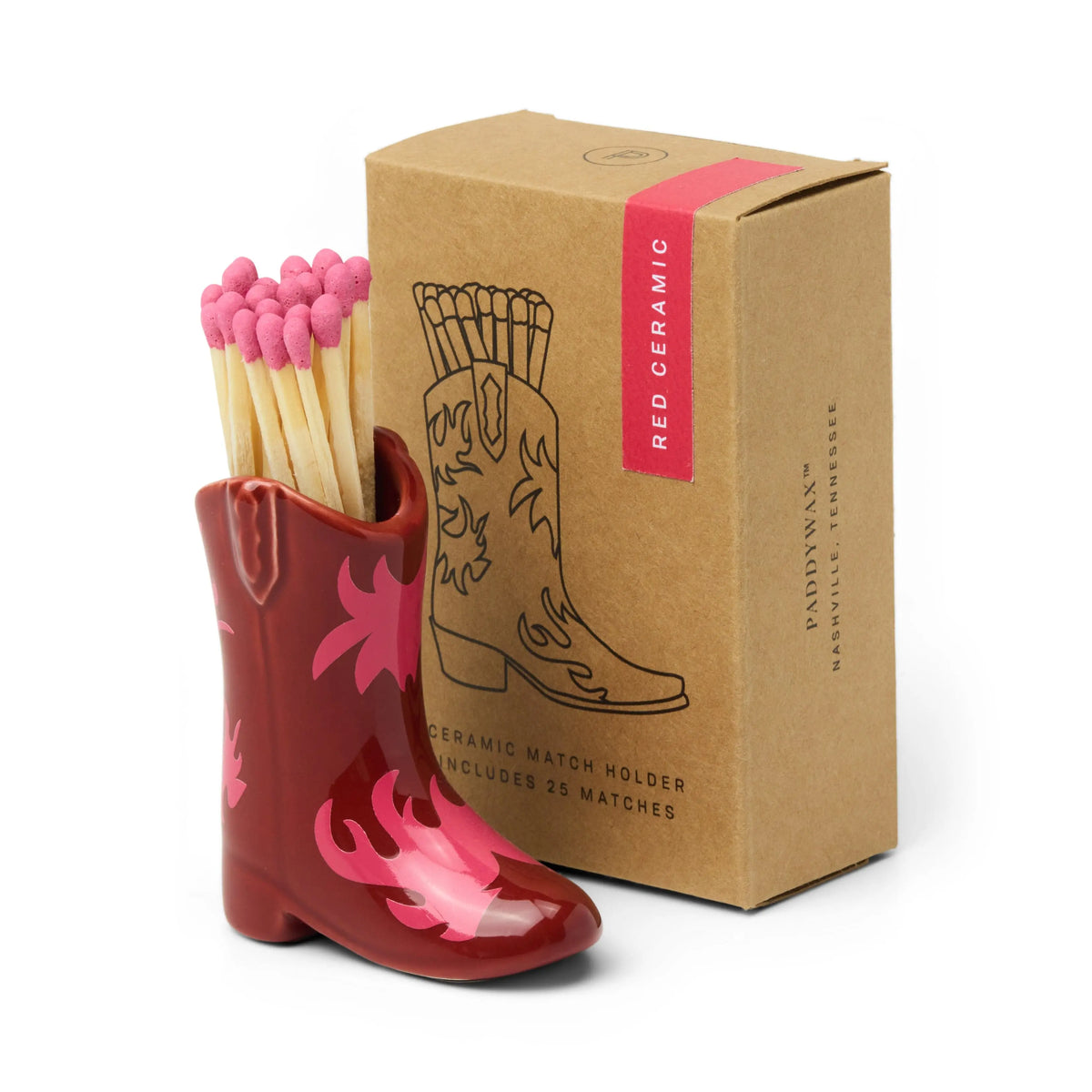 The Cowboy Boot Match Holder - Red & Pink Flame is a striking red ceramic piece filled with pink-tipped matches, making it an ideal Nashville gift or standout Western home decor; it comes with a box featuring a boot illustration and the label "Red Ceramic.