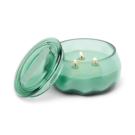 The Fresh Air & Sea Salt - Basalt 10 oz Candle, a green glass jar candle featuring three glowing wicks and a matching lid resting beside it, captures the refreshing ambiance of coastal living—perfect for anyone longing for the crisp scent of an ocean breeze.