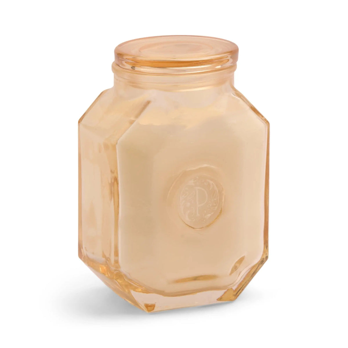 The Cotton + Teak - Botanica 8 oz Candle features a hexagonal glass jar with a matching lid and cream-colored wax, offering a luxurious home fragrance experience—perfect for candle lovers.