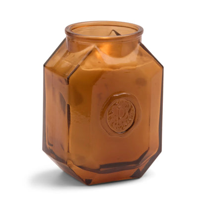The Leather + Smoke - Botanica 8 oz Candle features an elegant brown, hexagonal glass jar with a raised circular emblem—perfect for adding sophistication to any space.