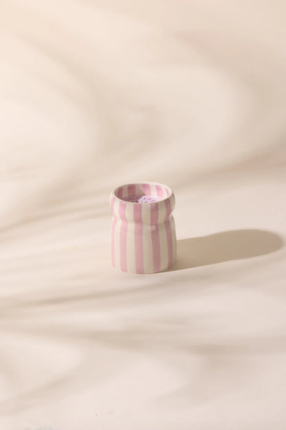The Grecian Sand - Cabana 6.5 oz Candle features a small ceramic vessel with vertical pink and white stripes, ideal for creating a relaxing coastal vibe with your favorite hand-painted candles or soothing scents.