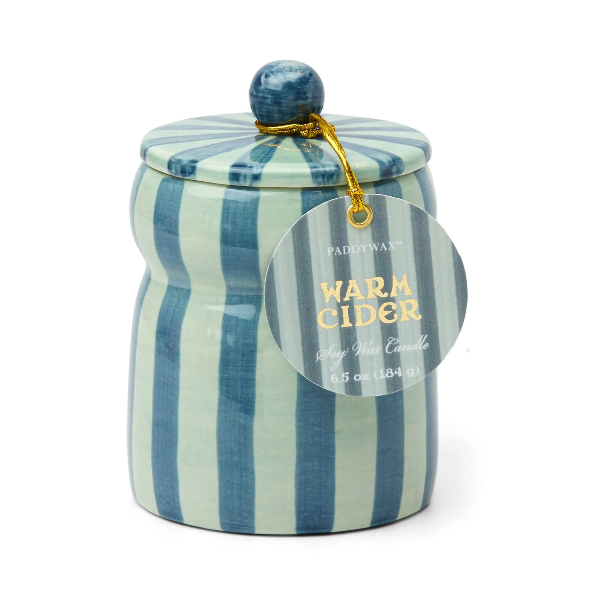 The Warm Cider - Cabana 6.5 oz Candle is a blue and light green striped hand-painted ceramic vessel with a lid, filled with Paddywax soy wax and fragranced with mulled cider. A gold string secures a round tag to the lid.
