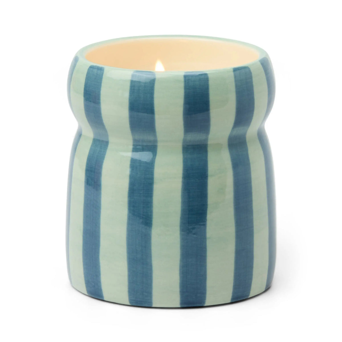 The Warm Cider - Cabana 6.5 oz Candle comes in a hand-painted ceramic vessel with vertical blue and light blue stripes. Its curved, glossy holder emits a cozy mulled cider fragrance when lit.