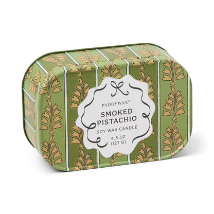 A green tin adorned with gold leaf patterns contains the Smoked Pistachio - Chérie 4.5 oz Tin Candle from Paddywax. Featuring a gourmand-inspired fragrance and crafted from soy wax, this elegant candle comes in a reusable tin, making it a sophisticated addition to any space.