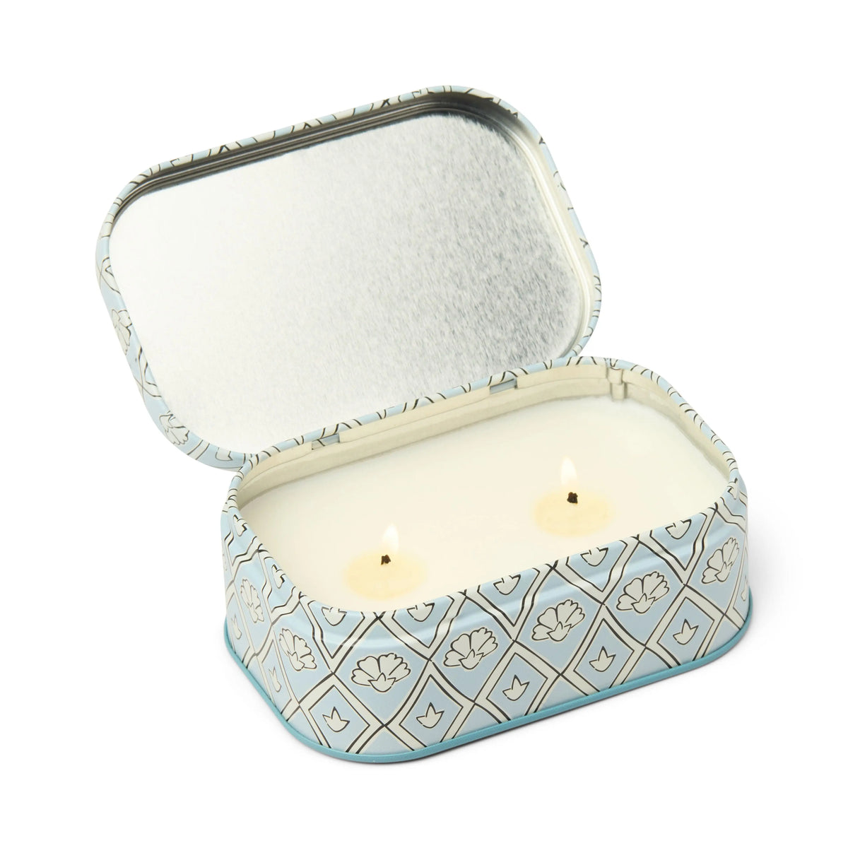 The Lavender & Thyme - Chérie 4.5 oz Tin Candle features a blue and white patterned rectangular tin holding a double-wick white scented candle. Its lid is open and positioned upright behind the lavender and thyme candle.