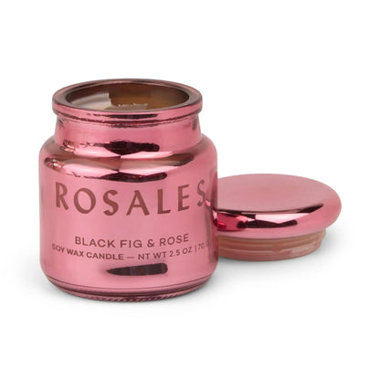 A shiny pink electroplated glass candle jar labeled Saffron Rose - Chroma 2.5 oz Candle with a matching lid placed beside it. Part of the Chroma Collection Candles, this Latin-inspired fragrance fills the air as the partially burnt candle glows inside.