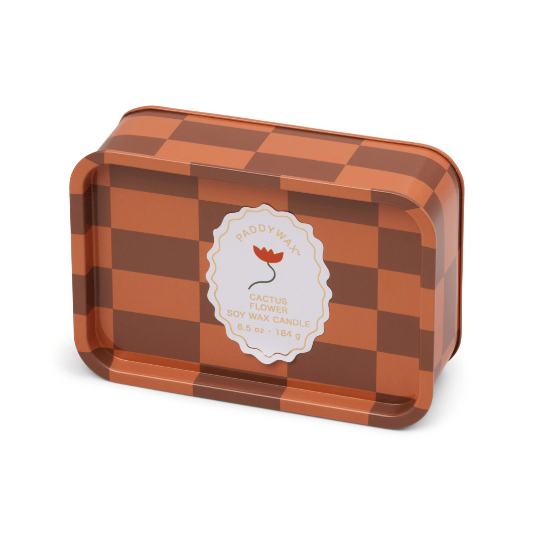 The Cactus Flower - A Dopo 6.5 oz Tin Candle features a rectangular tin with a brown and orange checkered design, white circular label, and red flower illustration—ideal for fans of bold fragrances in stylish tins.