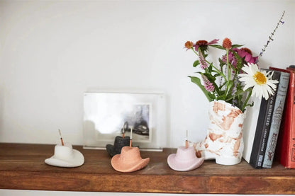 Four Cotton & Teak - Incense Holders rest on a wooden shelf beside a marbled vase of flowers, books, and a framed photo—an ideal Nashville gift for anyone who loves unique ceramic incense burner decor.