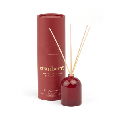 A Cranberry - 1.5 oz Diffuser features a red cylindrical container paired with a matching diffuser bottle and wooden reeds, making it a stylish, giftable home fragrance set.