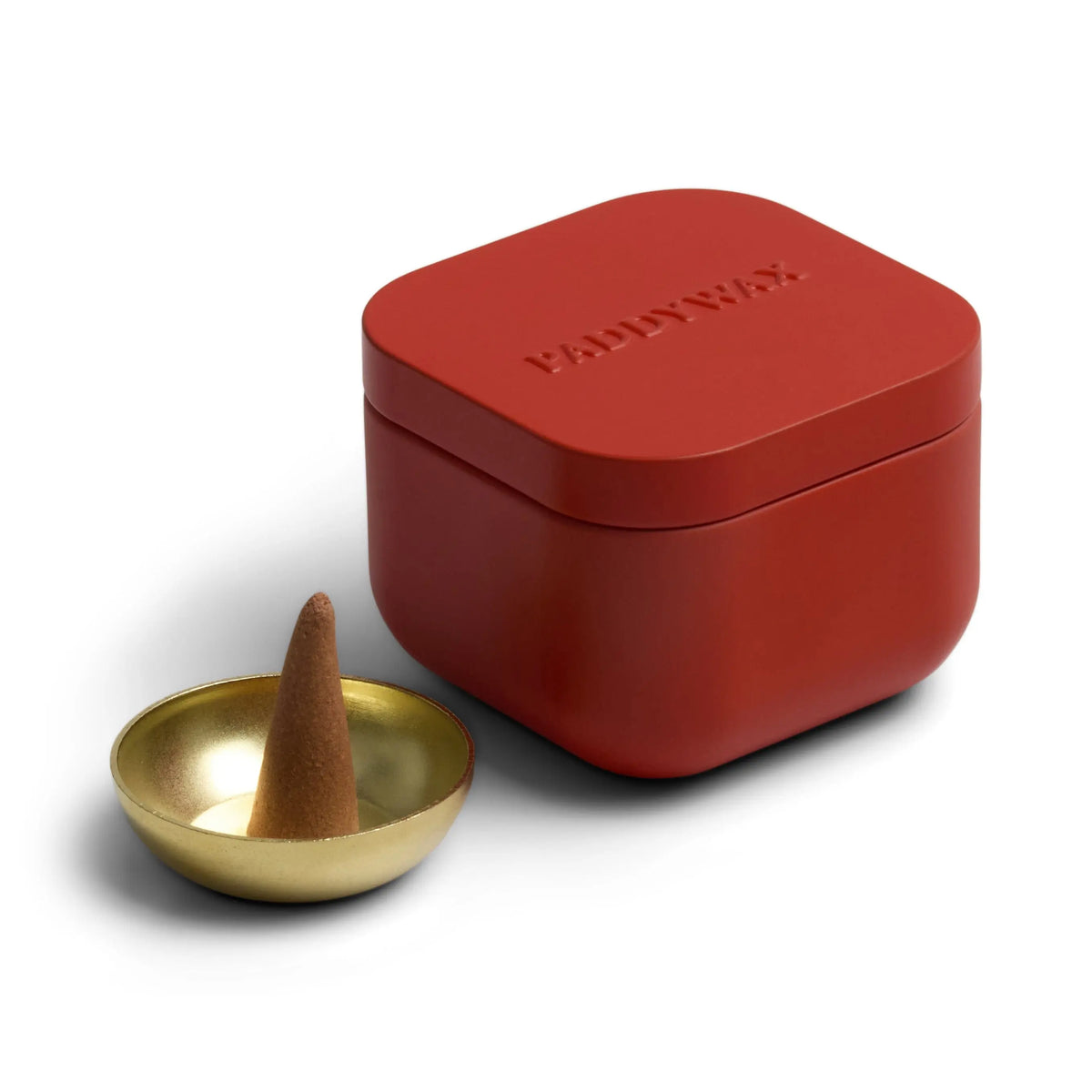 The Saffron Rose - Metal Incense Tin with its red box and lid sits beside a small gold incense holder cradling a brown scented incense cone, all arranged on a white background.
