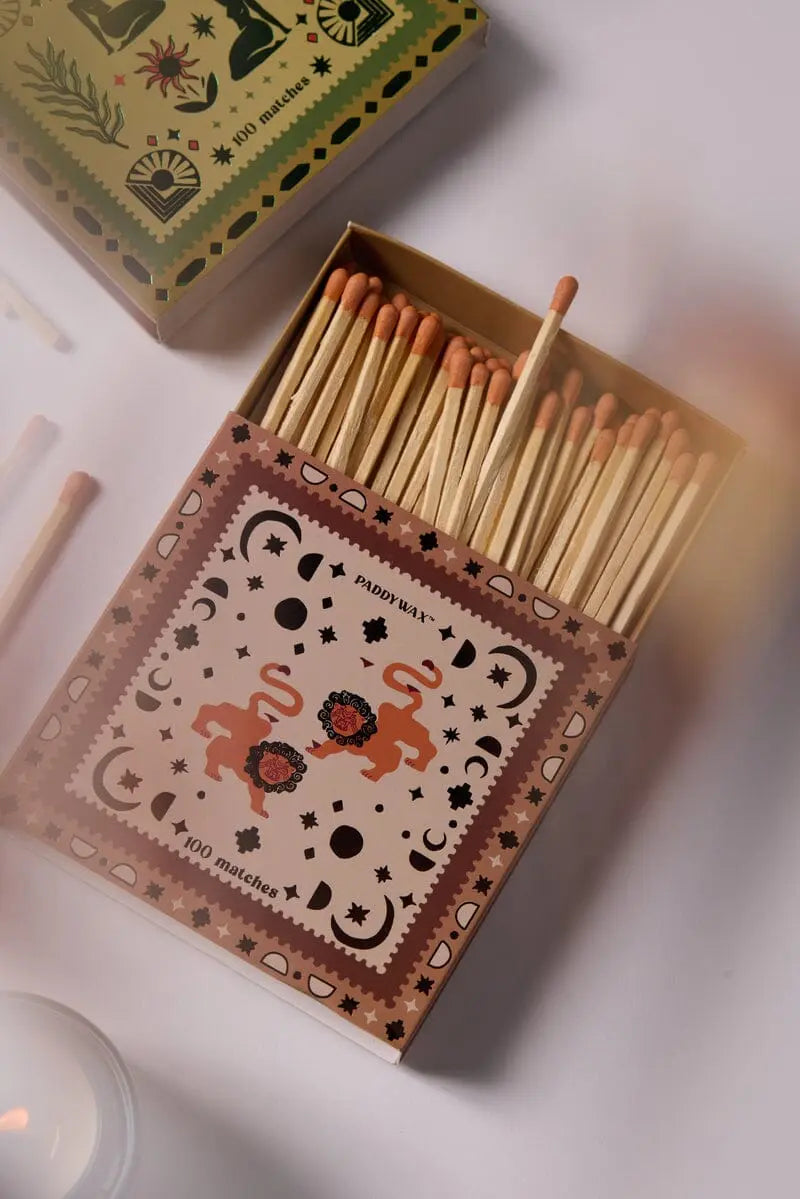 The Lions - Orange Matches decorative matchbox features a patterned design with two lions and flowers, filled with wooden jumbo matches and displayed open on a white surface.