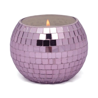 The Lavender Fern - Magique Disco Ball 10 oz candle features a round holder adorned with small, square, purple and silver mosaic tiles—ideal for disco candle lovers and anyone who enjoys sparkling décor.