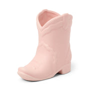 A light pink ceramic boot-shaped vessel featuring detailed stitching and a smooth, matte finish houses the Yuzu Woods - Nashville Boot 6 oz Candle—a Nashville-inspired accent perfect for adding a touch of western charm to any space.