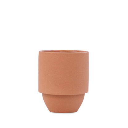 A plain, cylindrical planter with a smooth matte finish in a terracotta hue, inspired by the Grand Canyon - Parks 11 oz Candle collection, is displayed against a white background.