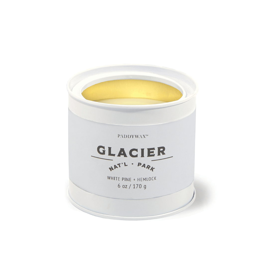The Glacier - Parks 6 oz Tin Candle features a white tin with Glacier Natl Park labeling, a gold interior, and delivers a White Pine + Hemlock scent inspired by the essence of US National Parks.