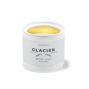 The Glacier - Parks 6 oz Tin Candle features a white tin with Glacier Natl Park labeling, a gold interior, and delivers a White Pine + Hemlock scent inspired by the essence of US National Parks.