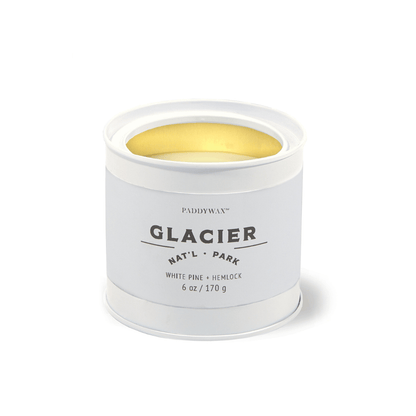 The Glacier - Parks 6 oz Tin Candle features a white tin with Glacier Natl Park labeling, a gold interior, and delivers a White Pine + Hemlock scent inspired by the essence of US National Parks.