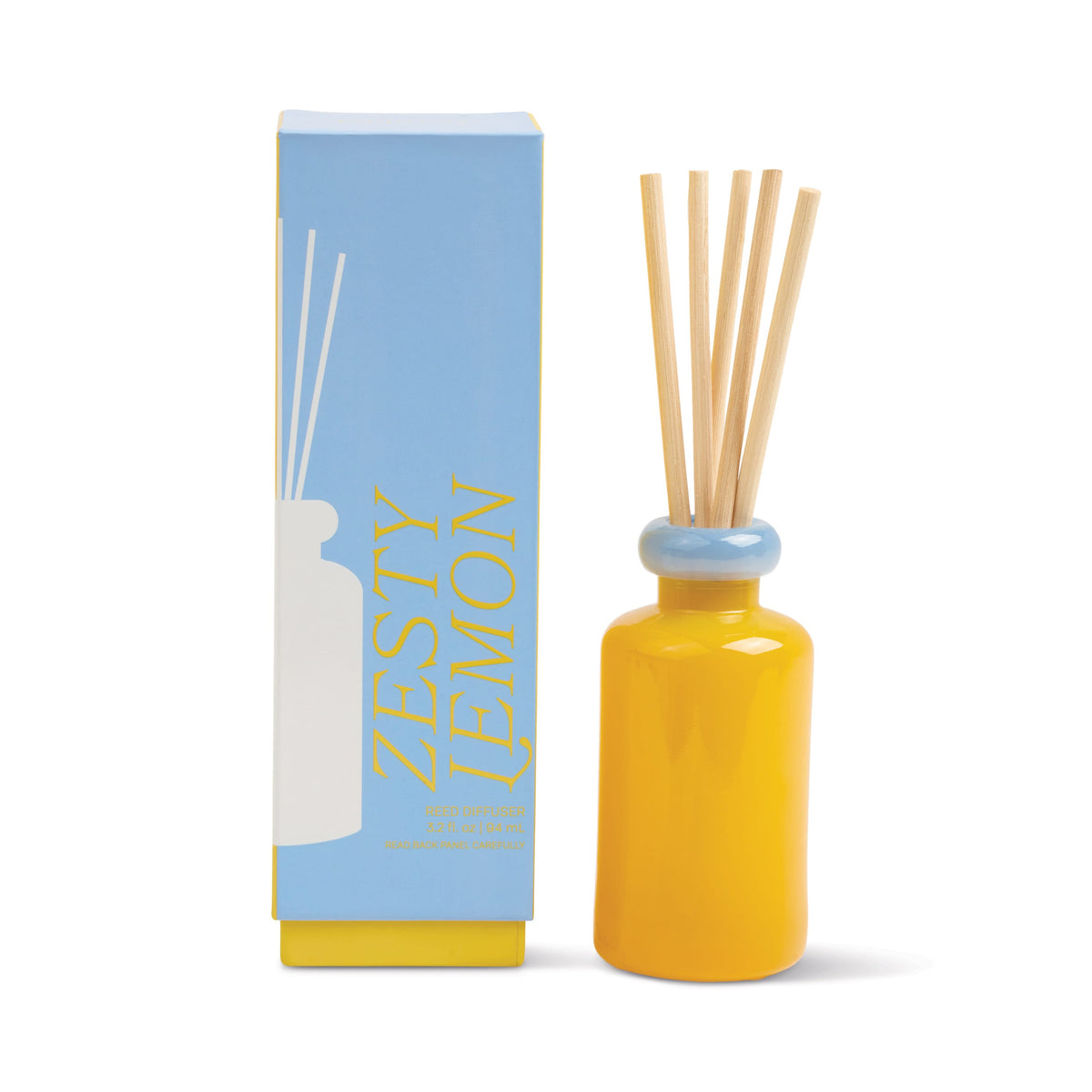 A yellow ceramic Zesty Lemon - Stack 3.2 oz Diffuser with wooden sticks sits by its blue and yellow box labeled Zesty Lemon. The box displays a minimalist bottle graphic and bold lettering, making it a perfect modern home fragrance.