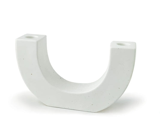 The U Taper Holder - White is a ceramic candle holder with brown speckles, flat sides, and small circular openings at the top of each end. It stands upright on flat surfaces.