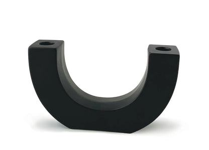 Introducing the U Taper Holder - Black: a sleek, U-shaped ceramic piece with flat sides and two small holes on top, designed to stand upright against a white background. Ideal as minimalist decor or as an eye-catching black candle holder, the U Taper Holder - Black artfully combines form and function.