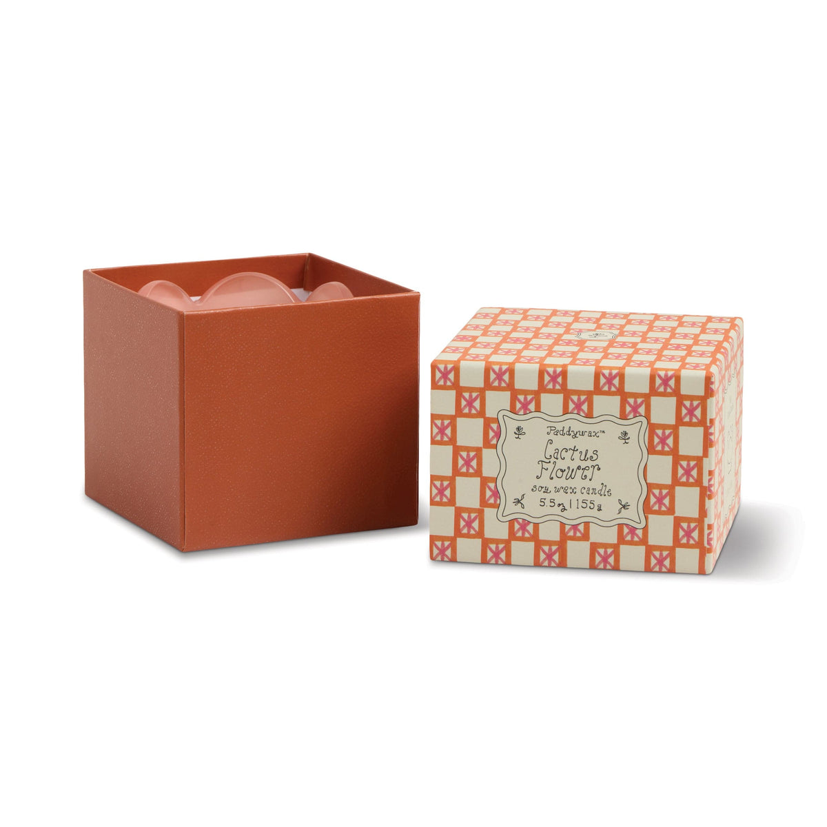 An orange box with its lid removed sits beside the patterned 'Cactus Flower - Tulip 5.5 oz Candle' lid, revealing pink contents—adding a charming touch to your decor and reminiscent of a stylish candle display.