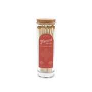 A glass jar with a cork lid filled with safety matches, labeled "Fireside Safety Matches - Gold" in white text on a red background, features white-tipped matches arranged upright—making it the perfect companion for lighting candles in your home.