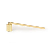 The Candle Snuffer, featuring a gold finish, cylindrical base, and an elongated flat handle, is presented as an elegant candle accessory against a white background.