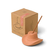 The Teak & Tobacco - Incense Holder features a cowboy hat design with a teakwood tobacco incense stick, displayed beside its brown cardboard packaging.
