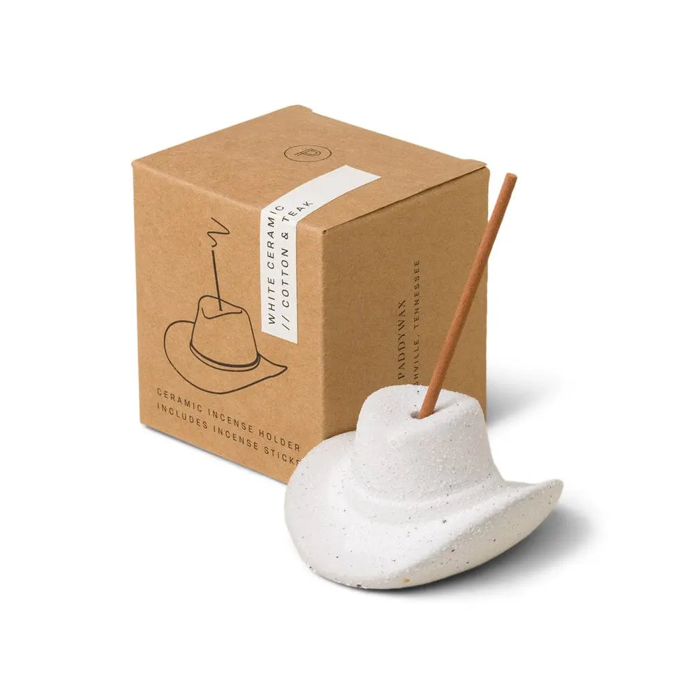 The Cotton & Teak - Incense Holder is a white ceramic cowboy hat, ideal as a Nashville gift, designed to hold a burning incense stick and comes in a box labeled "White Ceramic Cotton Hat.