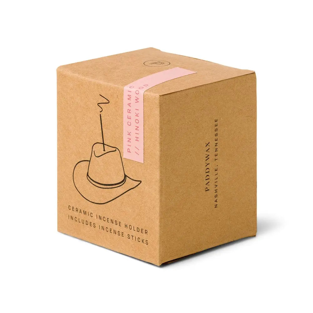 Minimalist brown box features a line drawing of a cowboy hat incense holder and is labeled "Hinoki Wood - Incense Holder." Packaging indicates it contains a ceramic incense burner and Hinoki wood incense sticks.