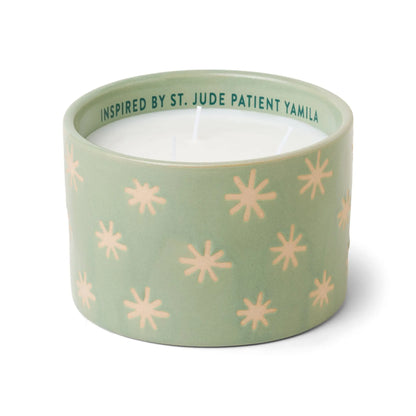The Mist + Mint - St. Jude Giveback "Inspire" 11 oz. Candle is a green ceramic candle holder from Paddywax, adorned with delicate starburst patterns and filled with white wax featuring three wicks. Inside the rim, it is inscribed with the text: INSPIRED BY ST. JUDE PATIENT YAMILA, making it a meaningful addition to your ceramic candles collection.
