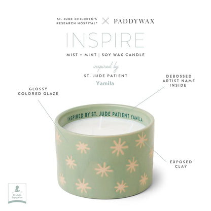 Mist + Mint - St. Jude Giveback "Inspire" 11 oz. Candle crafted with green soy wax in a Paddywax ceramic vessel, adorned with light pink starburst patterns and labeled INSPIRED BY ST. JUDE PATIENT YAMILA on the rim. This inspiring St. Jude candle features a glossy colored glaze, exposed clay accents, and a debossed artist name inside—supporting hope, creativity, and the work of St. Jude Children’s Research Hospital.