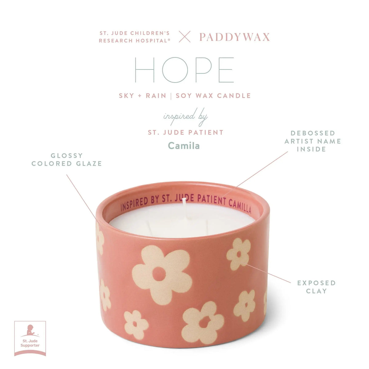 Introducing the Sky + Rain - St. Jude Giveback "Hope" 11 oz. Candle: a beautifully crafted pink ceramic candle featuring delicate white flowers, a glossy glazed finish, and exposed clay for an artisanal touch. Debossed inside with "INSPIRED BY ST. JUDE PATIENT CAMILA," this exclusive Paddywax and St. Jude collaboration is designed to inspire hope and strength while supporting a meaningful cause.