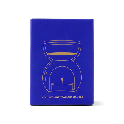 The Cobalt Blue Glass - Essential Oil Burner & Tea Light Candle features a minimalist gold line drawing of an oil burner and comes with one tealight candle included.