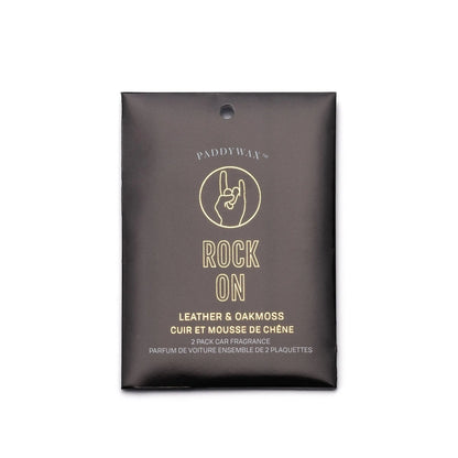 A black packet labeled "Leather + Oakmoss 'Rock On' - Impressions Car Fragrance" features a hand sign illustration and contains a 2-pack of hanging air fresheners for car fragrance.