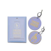 The Wisteria + Willow “Fingers Crossed” Impressions Car Fragrance set includes two round lavender hanging fresheners with a yellow fingers-crossed graphic, delivering uplifting scent for your car.