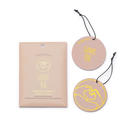 The "Love Ya" Tobacco + Vanilla Impressions Car Fragrance includes two round air fresheners with a hand heart illustration—ideal for those who enjoy unique scents and stylish car accessories.