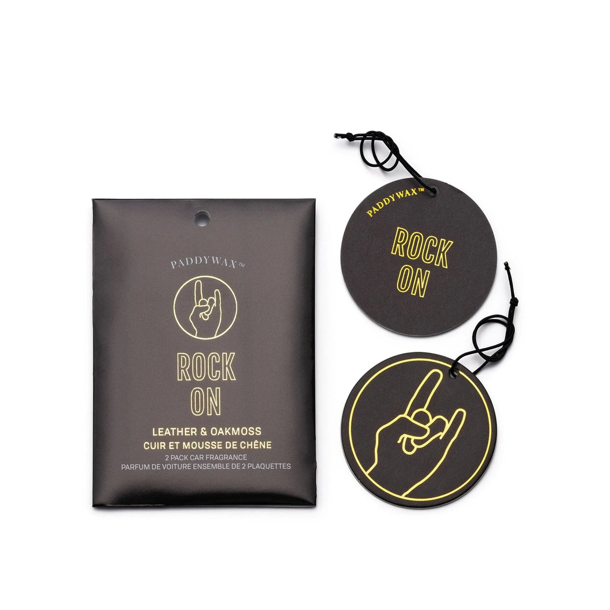 A set of two round black "Rock On" air fresheners with a hand sign, next to packaging labeled Leather + Oakmoss "Rock On" - Impressions Car Fragrance by Paddywax—perfect for bold, lasting car scents.
