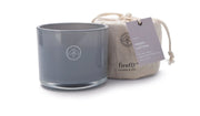 A gray glass “Fresh Cotton - Kindred 10 oz Candle” sits beside a linen bag with a tag reading “Fresh Cotton Soy Wax Candle,” making this candle set perfect for gifting or cozy evenings at home.