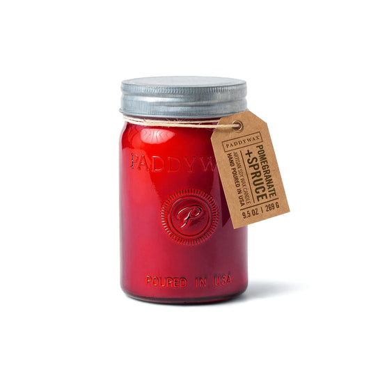 The Pomegranate & Spruce - Relish 9.5 oz Candle features hand-poured soy wax in a red mason jar with a silver lid, embossed design, and brown Paddywax tag—perfect for upcycling after enjoying its festive scent.