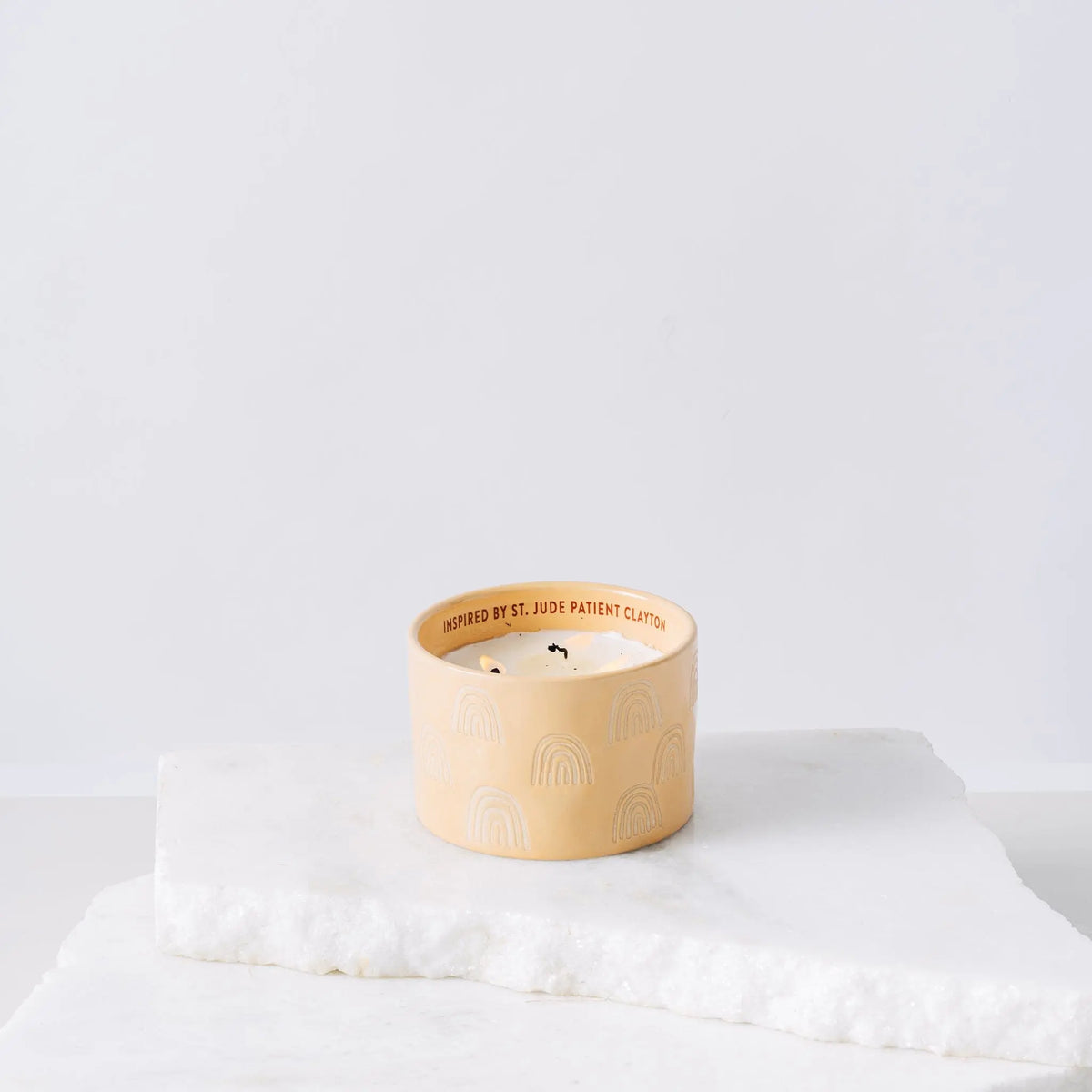 The Cactus Flower - St. Jude Giveback "Possibilities" 11 oz. Candle features a cream color with subtle rainbow patterns and text on the rim inspired by St. Jude patient Clayton, supporting the fight against childhood cancer.