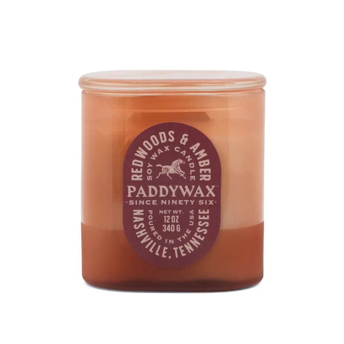 A brown glass vessel candle jar labeled Redwoods + Amber - Vista 12 oz Candle, featuring a round lid and displaying "12 oz (340 g)" along with "Nashville, Tennessee" on the front. This vintage-inspired candle is part of the Vista collection.